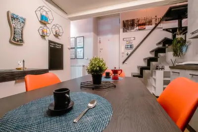 a dining room with a table and orange chairs at Marta's Home in Palermo