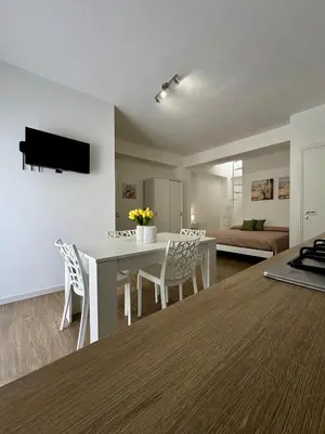 a kitchen and living room with a white table and chairs at TerrAmata in Terrasini