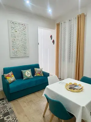 a living room with a blue couch and a table at Suite 196 - Central City Palermo in Palermo