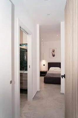 a white room with a bed and a bathroom at Acqua Marina Balestrate in Balestrate