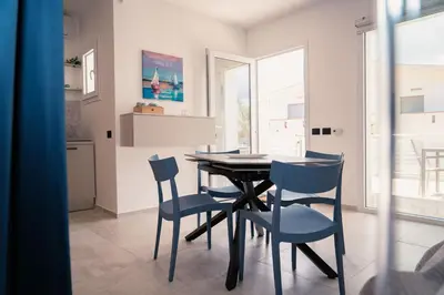 a dining room with a table and blue chairs at Acqua Marina Balestrate in Balestrate