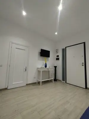 a white room with a door and a mirror at D'anthoine apartment in Palermo