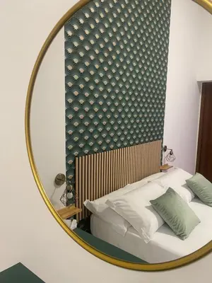 a mirror reflection of a bed in a room at Florio Rooms in Palermo