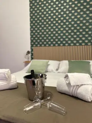 a table with a bucket and towels next to a bed at Florio Rooms in Palermo