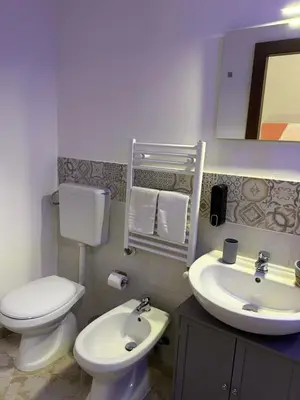 a bathroom with a white toilet and a sink at Florio Rooms in Palermo