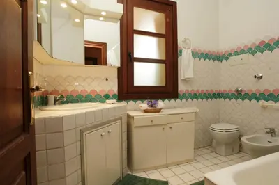 a bathroom with a sink and a toilet and a mirror at Giardino degli Ulivi in Palermo