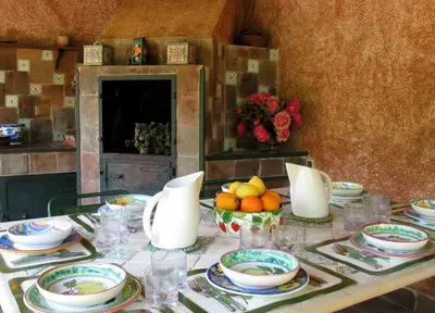 a table with plates and bowls of fruit on it at Giardino degli Ulivi in Palermo