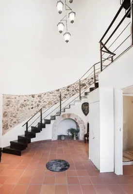 a staircase in a house with a stone wall at Torre Lanza di Guidaloca By DomuSicily in Castellammare del Golfo