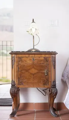 a wooden table with a lamp on top of it at Torre Lanza di Guidaloca By DomuSicily in Castellammare del Golfo