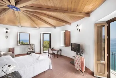 a bedroom with a bed and a desk and a tv at Torre Lanza di Guidaloca By DomuSicily in Castellammare del Golfo