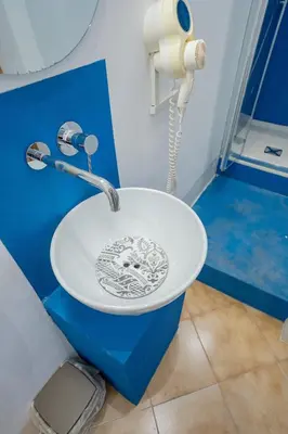 a white sink in a bathroom with a phone at Himera Domus 2 in Termini Imerese