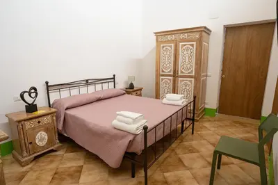 a bedroom with a bed and a wooden cabinet at Himera Domus 2 in Termini Imerese
