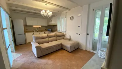 a living room with a couch and a kitchen at La Casa Di Maria in Carini