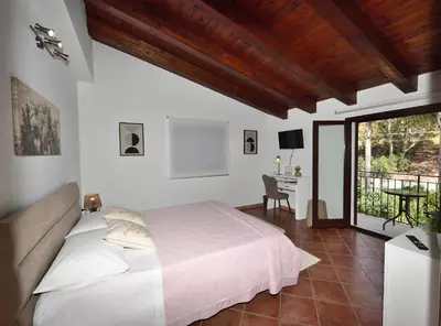a white bedroom with a bed and a desk at M&G Holiday House in Terrasini