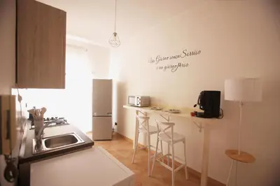 a kitchen with a counter with a sink and a refrigerator at Dream on the blue house Palermo in Palermo