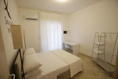 a bedroom with a white bed and a desk at Dream on the blue house Palermo in Palermo