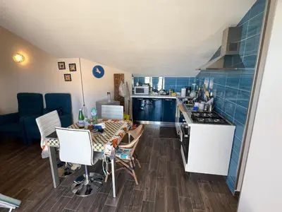 a small kitchen with a table with chairs and a stove at Fantastic, sea view apartment via Duchessa in Castellammare del Golfo