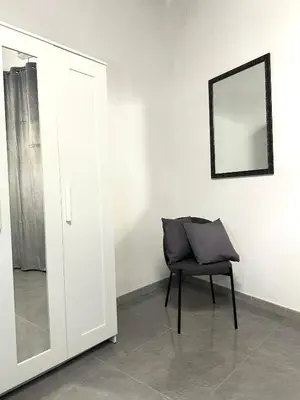 a chair sitting in a room with a mirror at Shamà rooms in Palermo