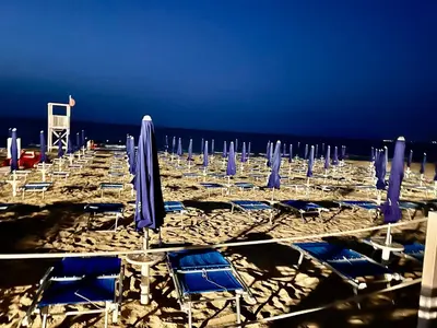a group of blue chairs and umbrellas on a beach at Fantastic sea view Via Duchessa in Castellammare del Golfo