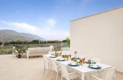 a white table and chairs on a patio at Historic Villa Overlooking Scopello Sea Stacks in Castellammare del Golfo