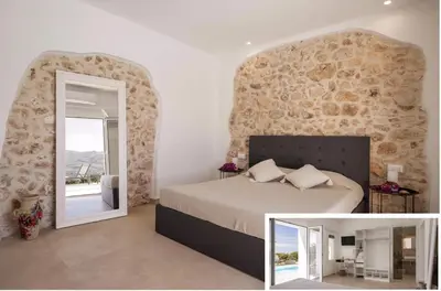 a bedroom with a large bed and a mirror at Historic Villa Overlooking Scopello Sea Stacks in Castellammare del Golfo
