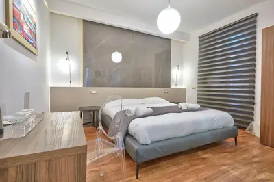 a bedroom with two beds and a table and a large bed at belMORO - La Dimora Del Capo in Palermo