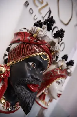 a statue of a black mask with a woman at belMORO - La Dimora Del Capo in Palermo