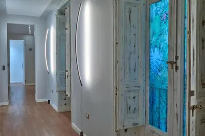 a hallway with white walls and blue glass doors at belMORO - La Dimora Del Capo in Palermo