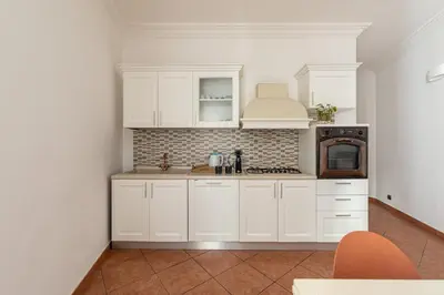 a kitchen with white cabinets and a stove top oven at Gorizia Apartment by Wonderful Italy in Palermo