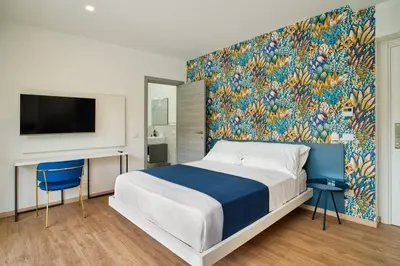 a bedroom with a large bed and a wall mural at Ella Suites Apartments in Terrasini