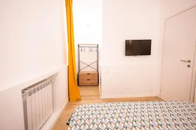 a bedroom with a bed and a tv on a wall at Flat in Center in Palermo