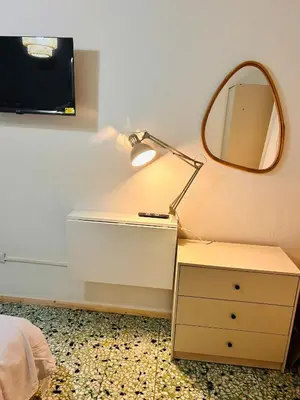 a table with a lamp and a mirror on a wall at Porte Rosse in Casteldaccia