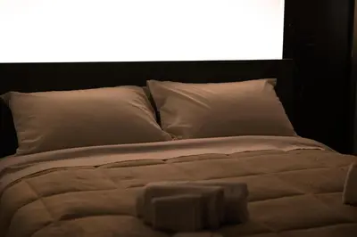 a bed with white sheets and pillows in front of a window at I Zingalini Affittacamere in Casteldaccia