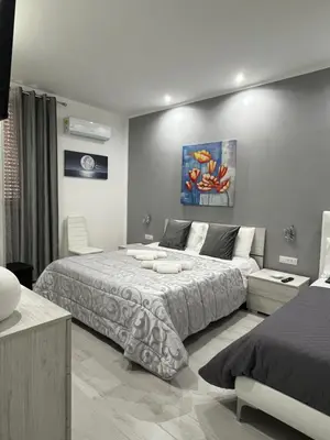a bedroom with a large bed and a couch at Angela apartments in Partinico