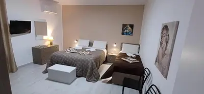 a small room with two beds and a table at Angela apartments in Partinico