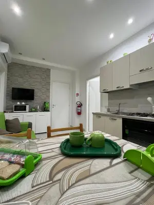 a kitchen and living room with a green tray on a table at Angela apartments in Partinico