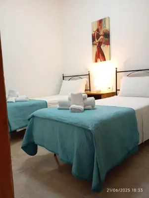 a bedroom with two beds with blue blankets on them at MuSa Apartament in Balestrate