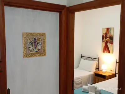 a bedroom with two beds and a picture on the wall at MuSa Apartament in Balestrate
