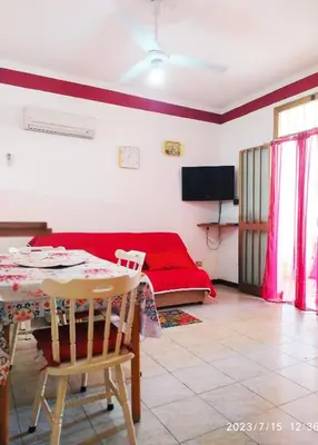a living room with a red couch and a table at MuSa Apartament in Balestrate