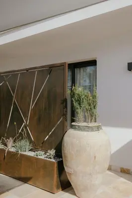 a large vase with plants in it next to a wall at Palmar Boutique Hotel in Campofelice di Roccella