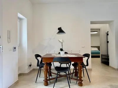 a dining room with a wooden table and chairs at Casa Baglio Monti in Palermo