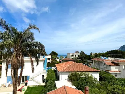 a view of a city with houses and a palm tree at Oasi Palma - Mondello in Palermo