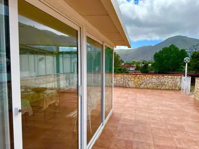 a glass door of a house with mountains in the background at Oasi Palma - Mondello in Palermo