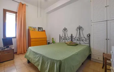 a bedroom with a green bed and a dresser at Beach Front Apartment In Trappeto in Trappeto