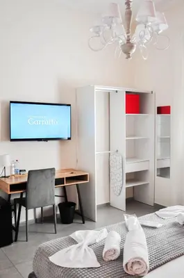 a bedroom with a desk and a tv on a wall at Foresteria del Genio - Luxury Suites & Urban Spa in Palermo