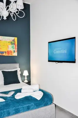 a bedroom with a bed and a flat screen tv at Foresteria del Genio - Luxury Suites & Urban Spa in Palermo