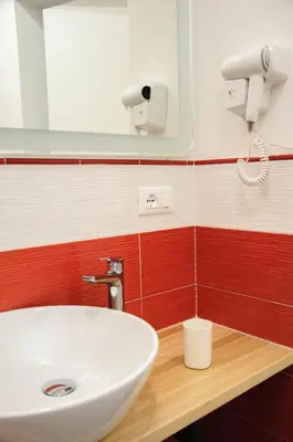a bathroom with a white sink and a hair dryer at Foresteria del Genio - Luxury Suites & Urban Spa in Palermo