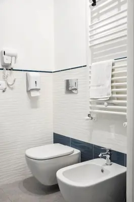 a white bathroom with a toilet and a sink at Foresteria del Genio - Luxury Suites & Urban Spa in Palermo