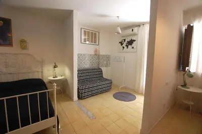 a living room with a couch and a chair at Appartamento Bouganville in Castellammare del Golfo
