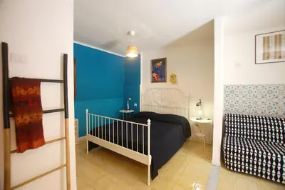 a bedroom with a crib and a blue wall at Appartamento Bouganville in Castellammare del Golfo